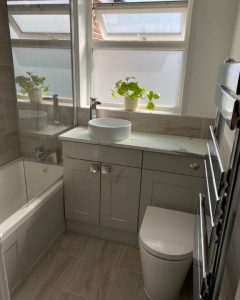 A new bathroom installation featuring bathroom cabinets with integrated sink, a new WC and a shower over bath.