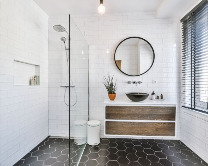 A contemporary bathroom design featuring a walk-in shower, floating cabinet with sink and a mirror on the wall.