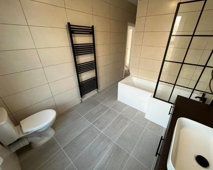 A bathroom that has had new tiles installed on the floor and walls.