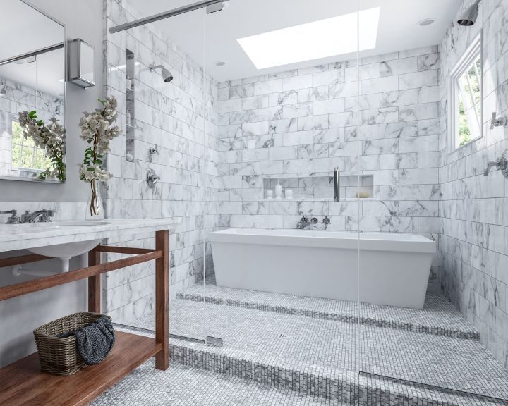 A modern wet room installation in Basingstoke featuring tiled floors and walls, a new bath and shower and a sink with cabinet.