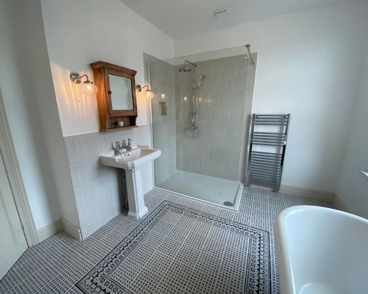 A wet room in Basingstoke featuring a walk-in shower and tiled floors.